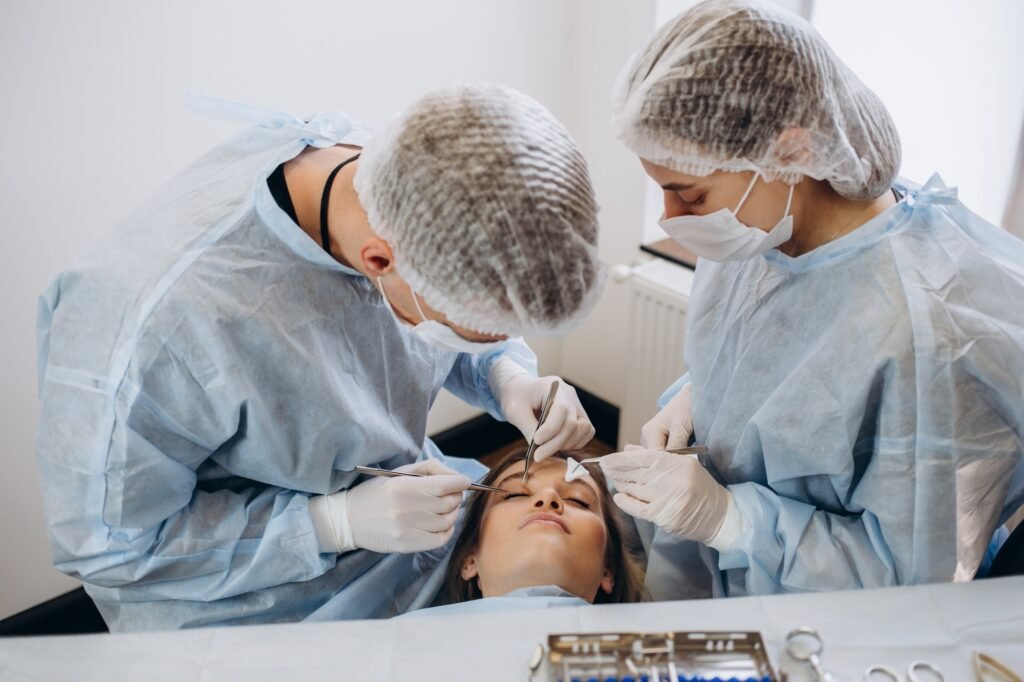 Team of surgeon in uniform perform operation on a patient at plastic surgery clinic